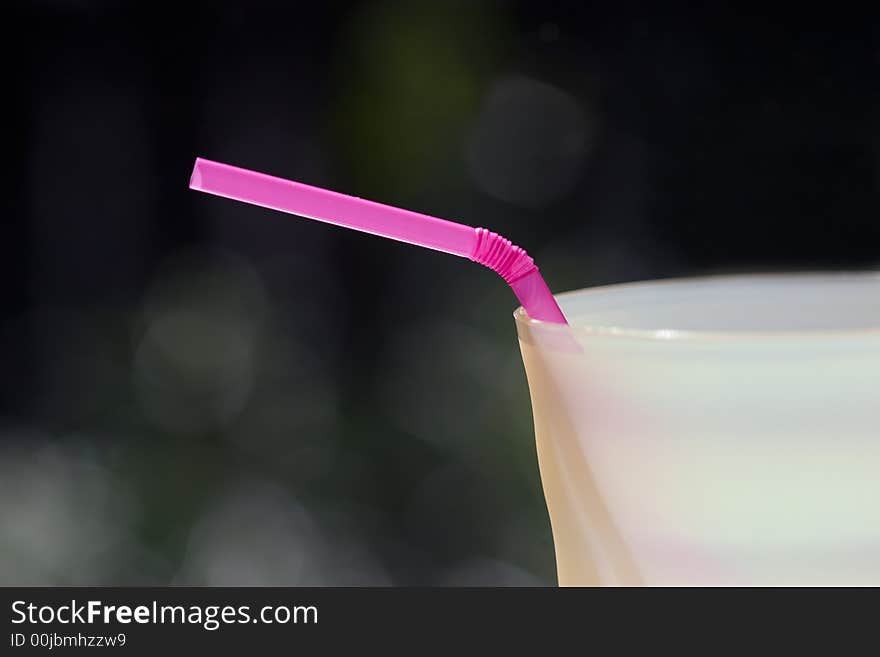 Close-up of a pink bendable straw in a yellow cup. Close-up of a pink bendable straw in a yellow cup.