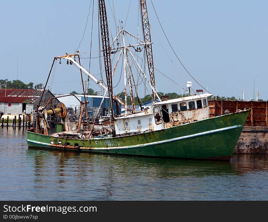 A rusty old shipwreck lies abandoned in the harbor in the Outer Banks of North Carolina. A rusty old shipwreck lies abandoned in the harbor in the Outer Banks of North Carolina