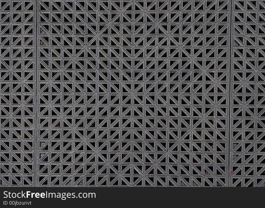 The symmetrical pattern of a textured rubber mat.