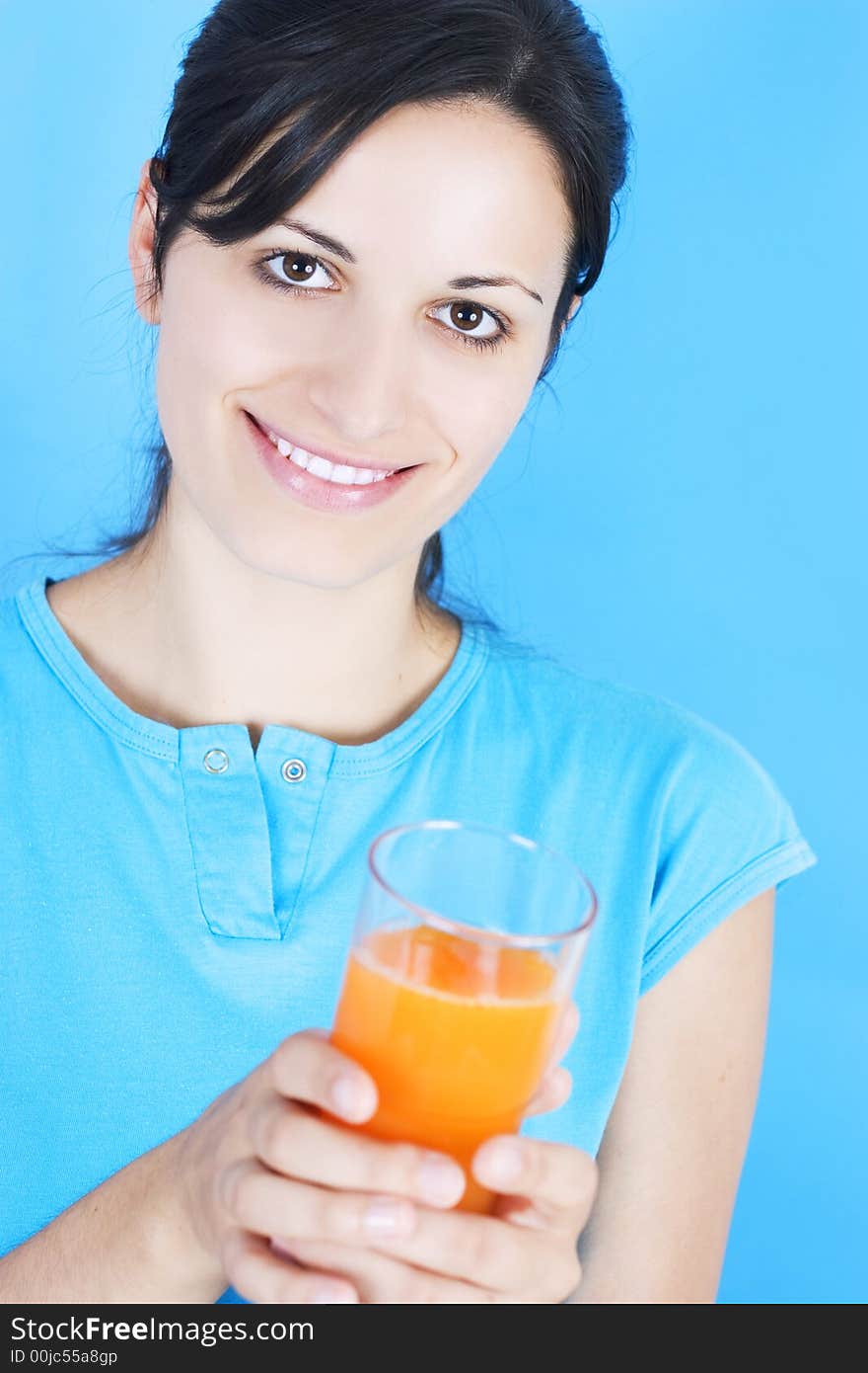 Young girl drinking juice on blue background