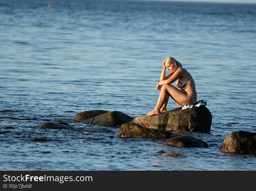 Girl sitting on the stone ,thinking