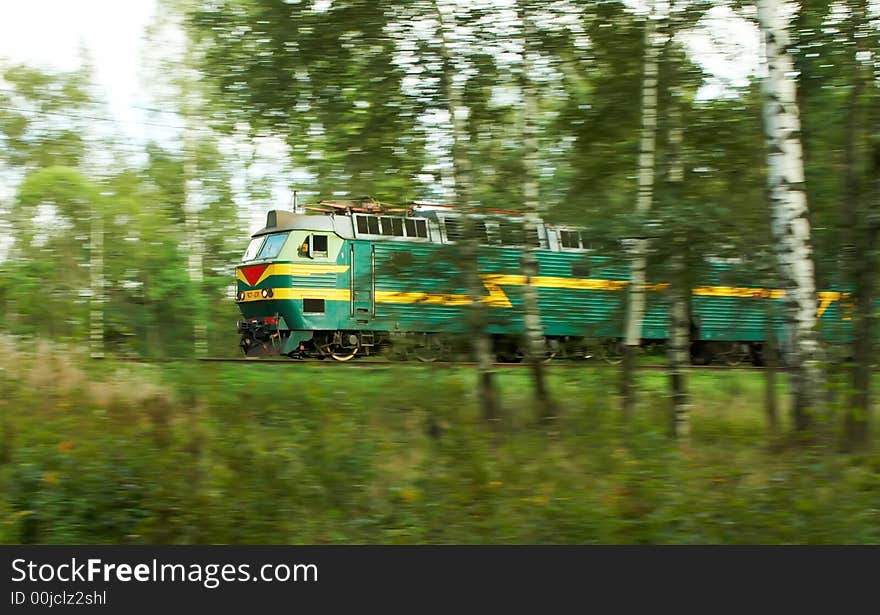 A passanger locomotive moving through a forest on a sunny day. A passanger locomotive moving through a forest on a sunny day.