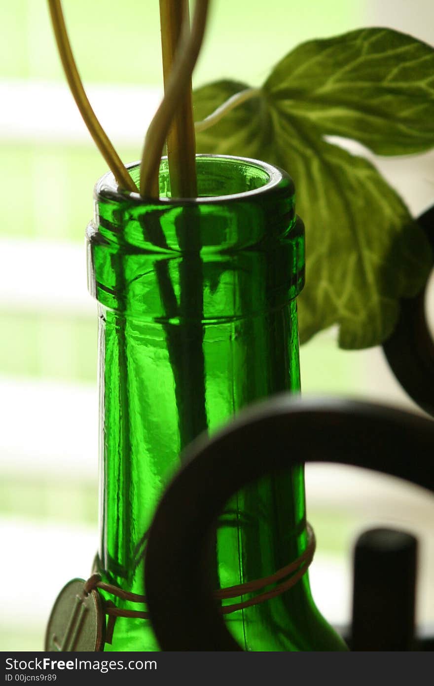 A detail of a wine bottle with vine and iron artwork.