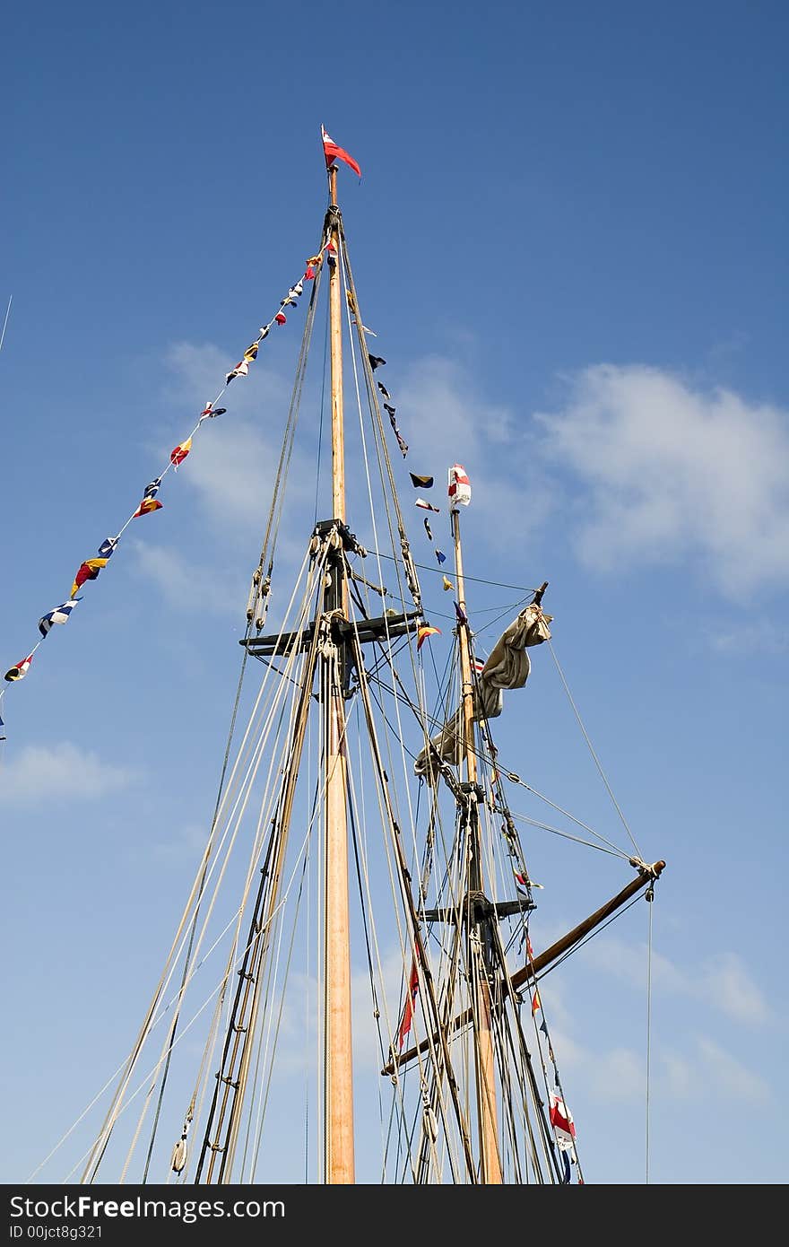 Masts of a sailing ship against a blue sky