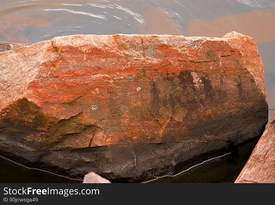 Big rocks laying in the water at the beach. Big rocks laying in the water at the beach