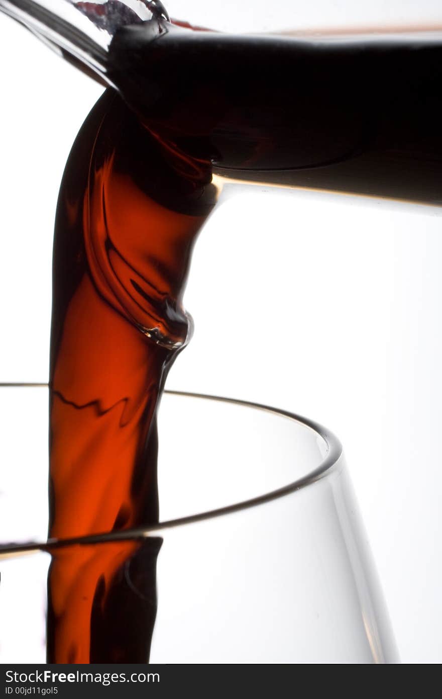 A close shot of wine pouring from a decanter into wineglass. A close shot of wine pouring from a decanter into wineglass