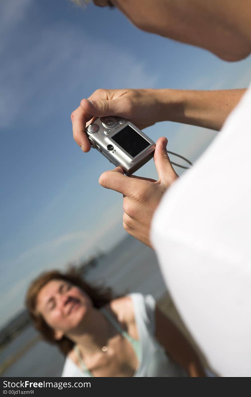 Young couple on the beach taking pictures