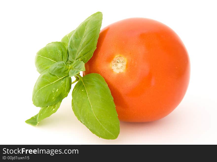 Tomato with basil isolated over white background