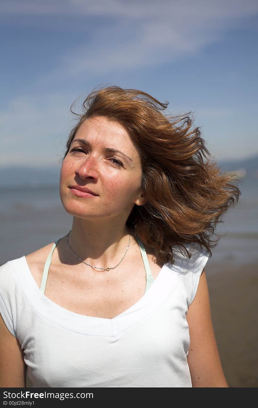 Woman close up portrait with her hair in the wind