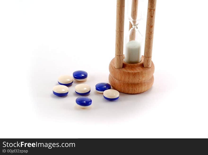 Pills laying next to a hourglass. Pills laying next to a hourglass