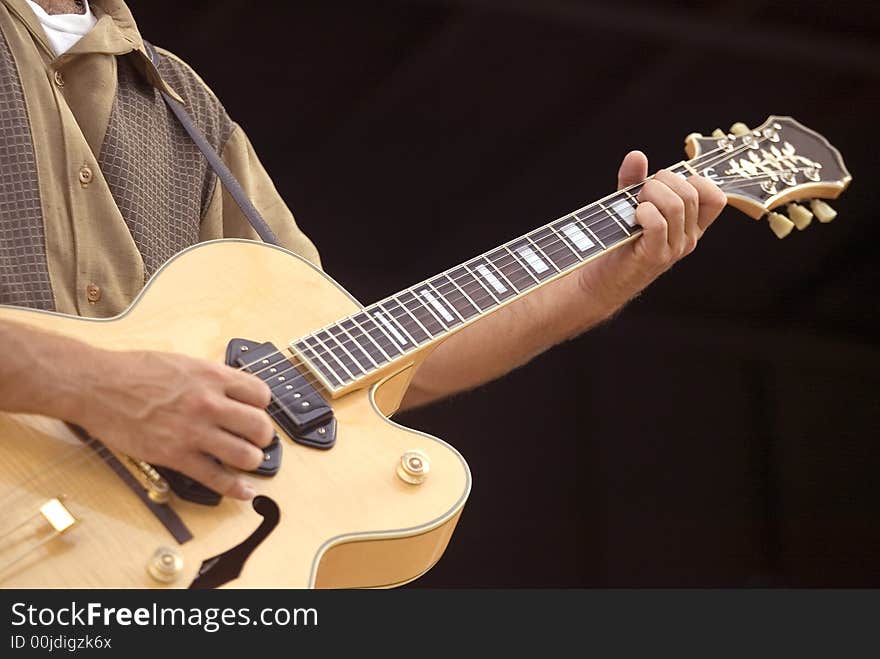 Close-up of a guitar player during a performance. Close-up of a guitar player during a performance.