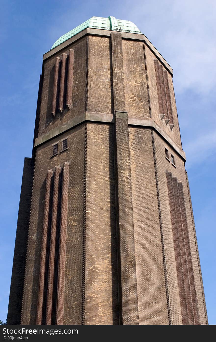 A water tower with a copper roof against a blue sky