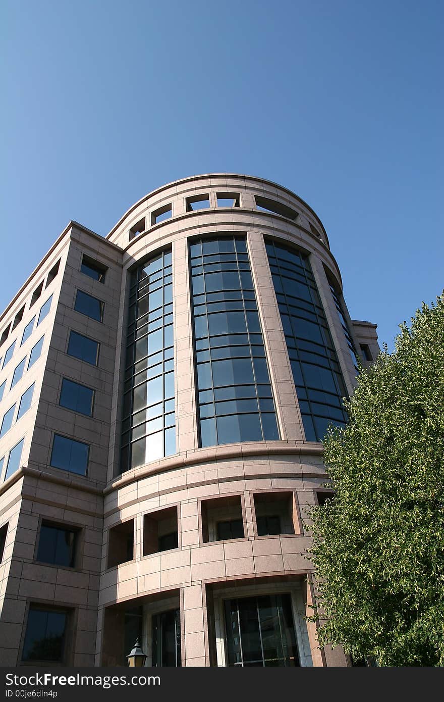 The curved glass front of a modern office building. The curved glass front of a modern office building