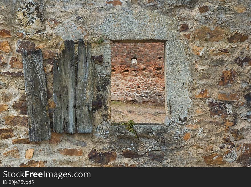 Old windowshutter hanging on the wall of a destroyed house. Old windowshutter hanging on the wall of a destroyed house