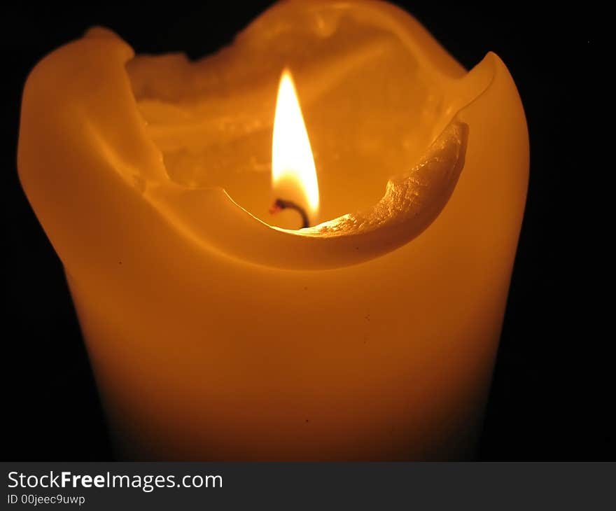 Burning candle in dark church