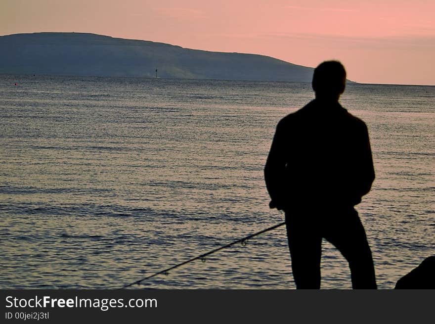 Fisherman on the Rocks in Galway Bay Fishing at dusk. Fisherman on the Rocks in Galway Bay Fishing at dusk