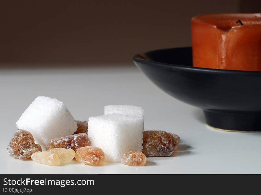 Cane sugar, lump sugar and a candle. Cane sugar, lump sugar and a candle