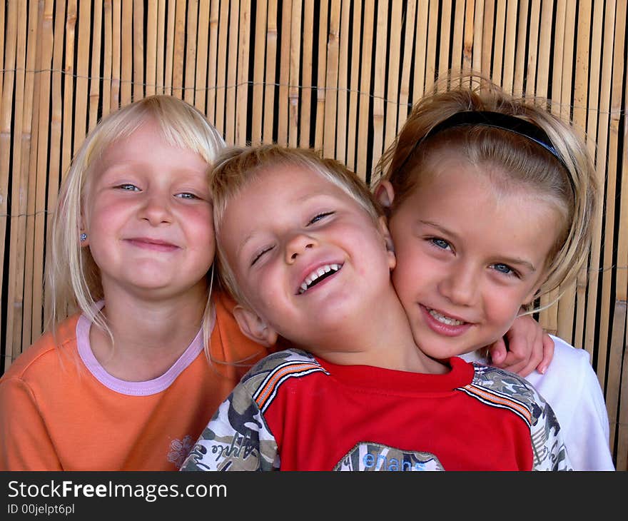 Brothers and sister sitting and smilling. Brothers and sister sitting and smilling.