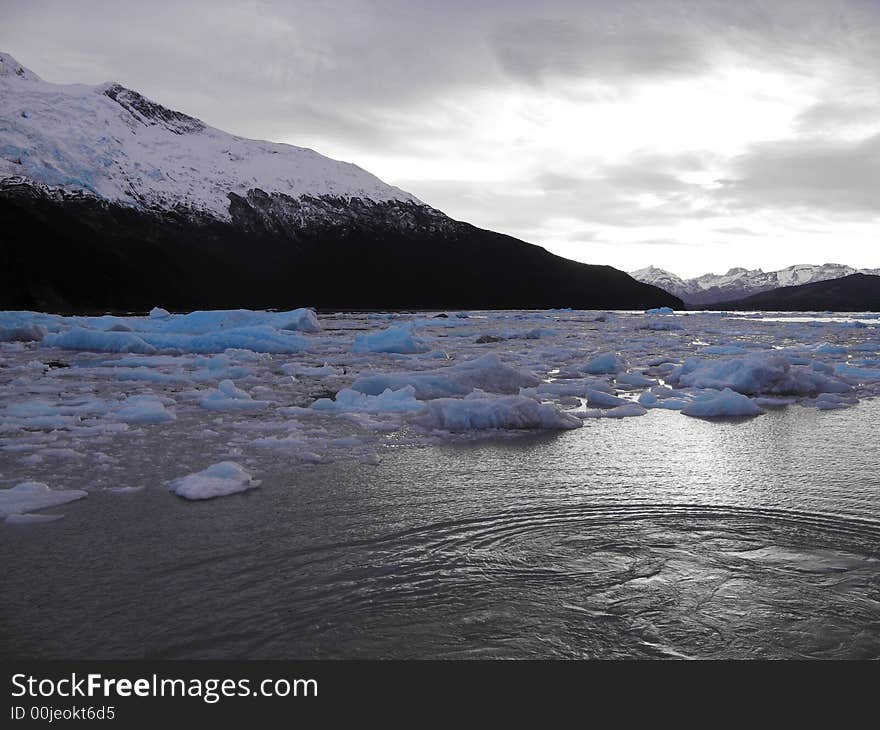 Floating icebergs surrounded by mountains in Argentina Lake