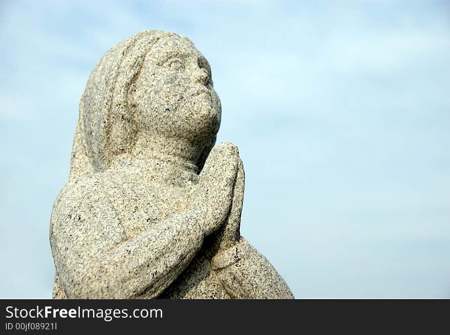 Praying statue with focus on hands