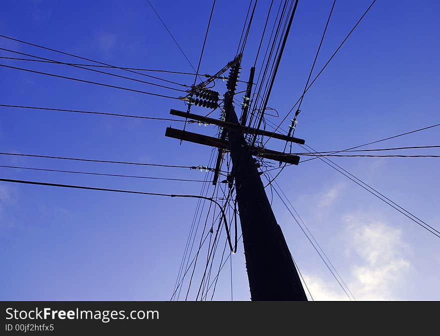 Power lines across the sky from a main pole