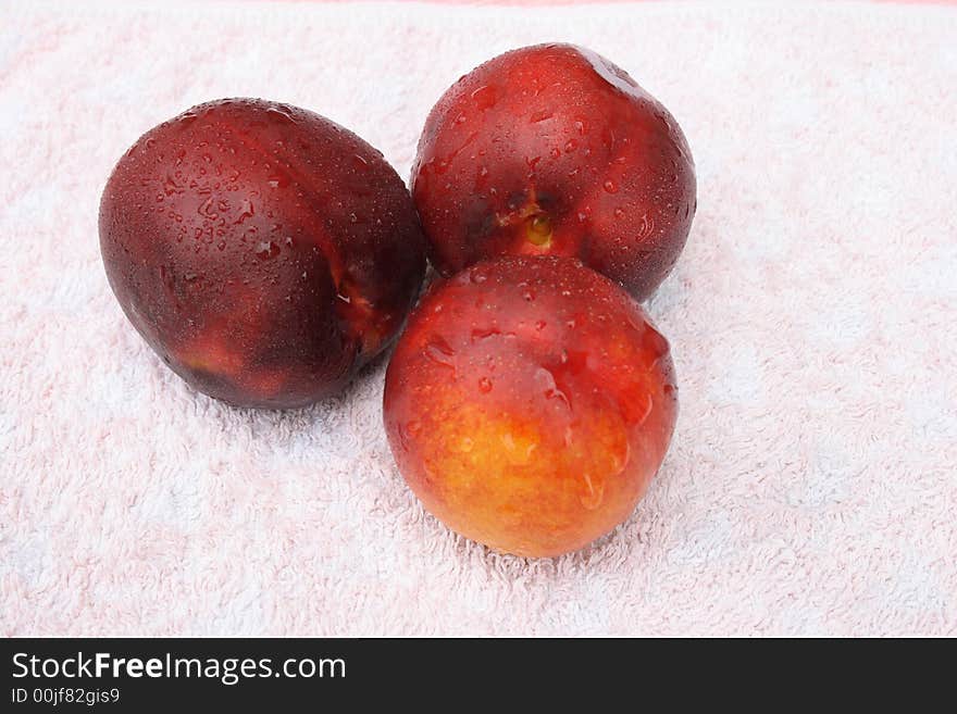 Peaches on a towel with drops of water