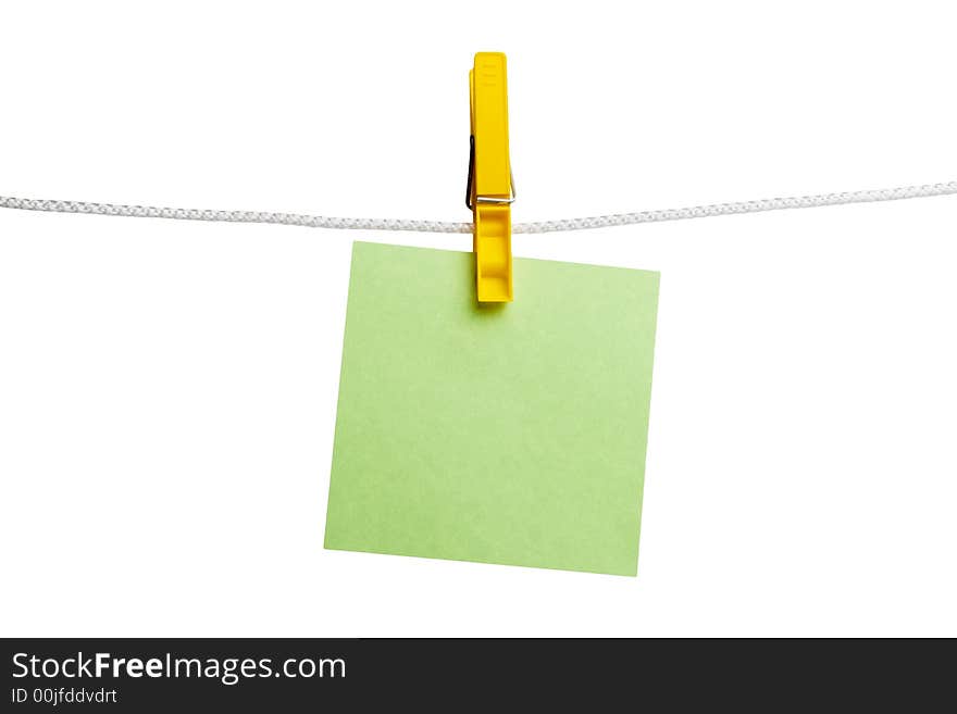 Green paper on yellow clothespin hanging on a cord isolated on a white background