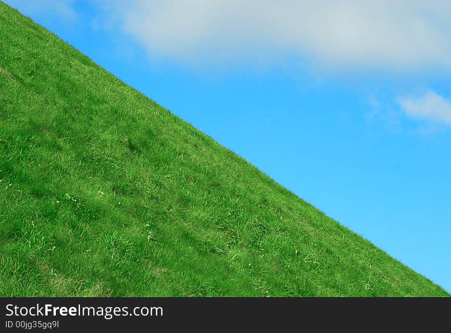 Background the blue sky with clouds and a green grass. Background the blue sky with clouds and a green grass