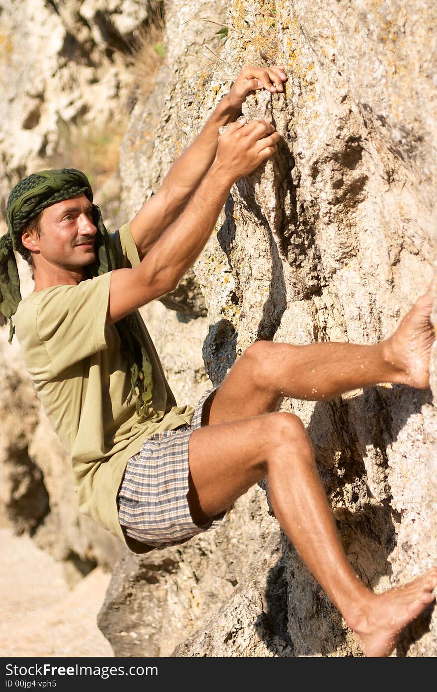 Rock climber man is climbing a very steep rock