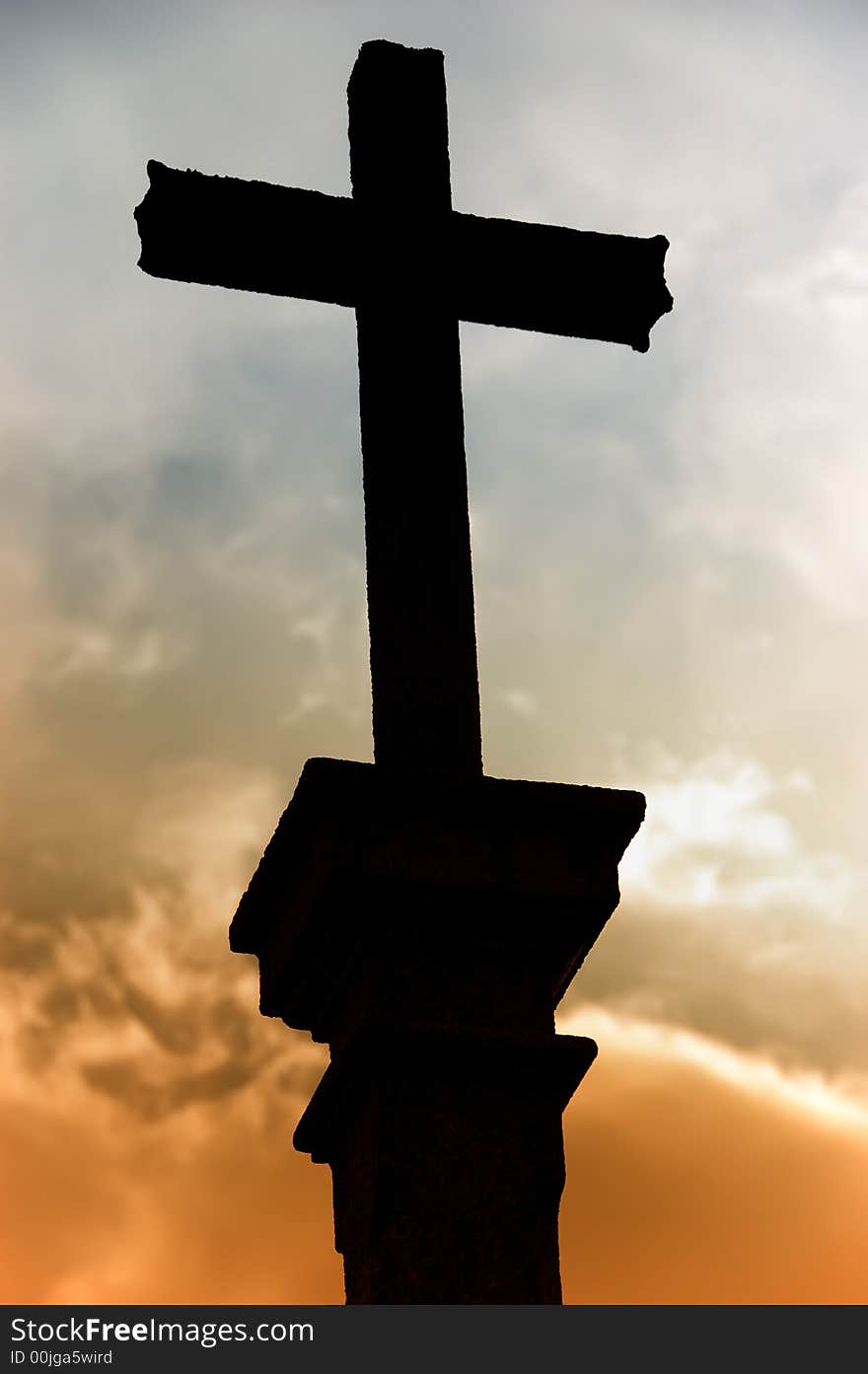 Cross silhouette and the clouds at sunset