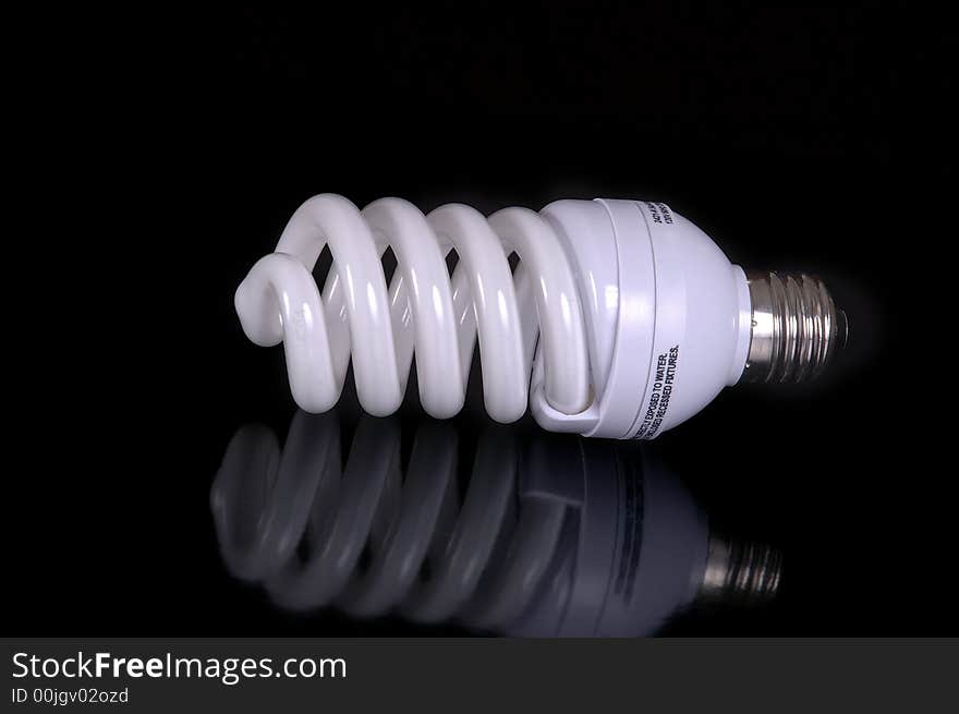 A fluorescent light bulb against a black background.