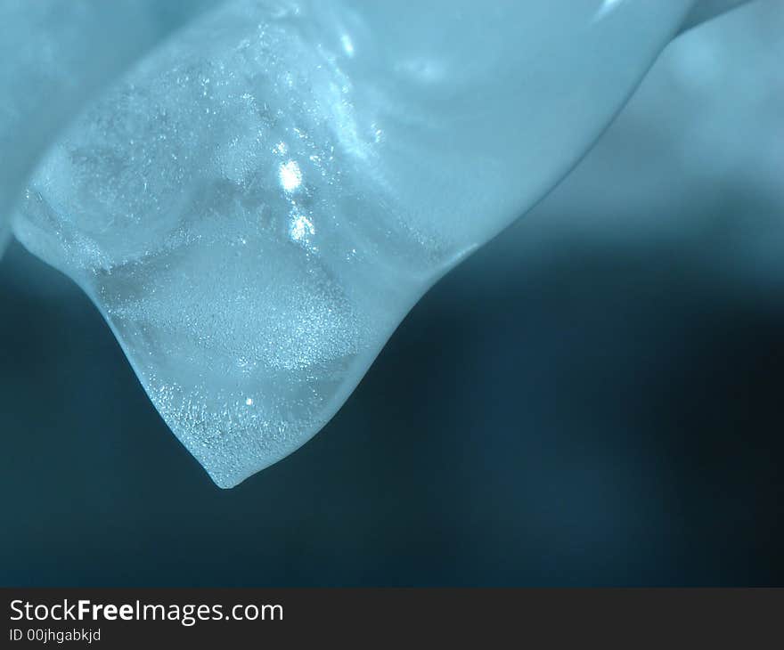 Melting icicle, a few seconds before its frozen peak is to turn into drop of water. Melting icicle, a few seconds before its frozen peak is to turn into drop of water.