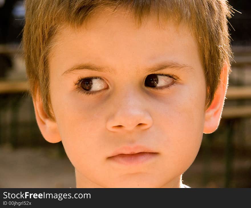 The sad little boy looks aside from photographer. The sad little boy looks aside from photographer