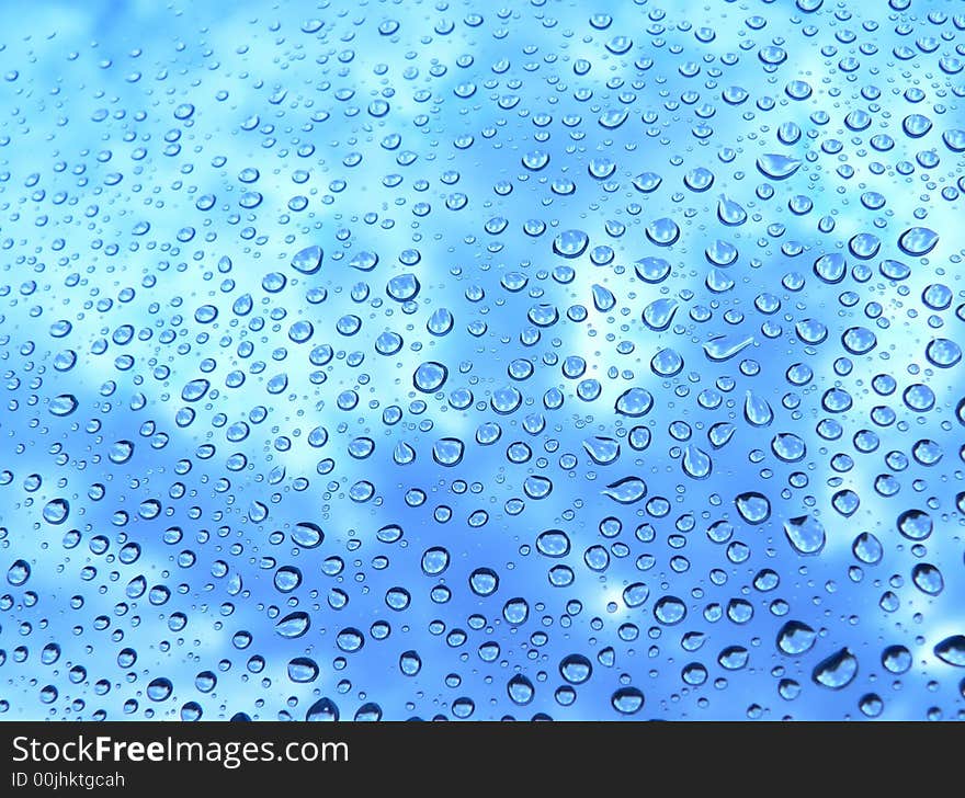 Water drops on glass against the sky