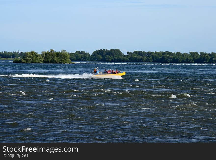 Tourists in a jet boat in a rapid stream. Tourists in a jet boat in a rapid stream.