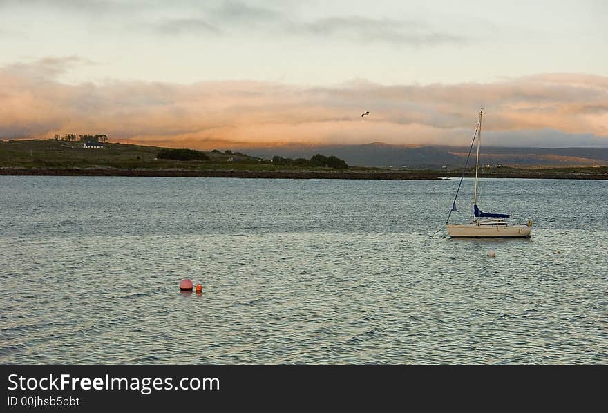 Sailing boat at Roundstone (Ireland) at sunset