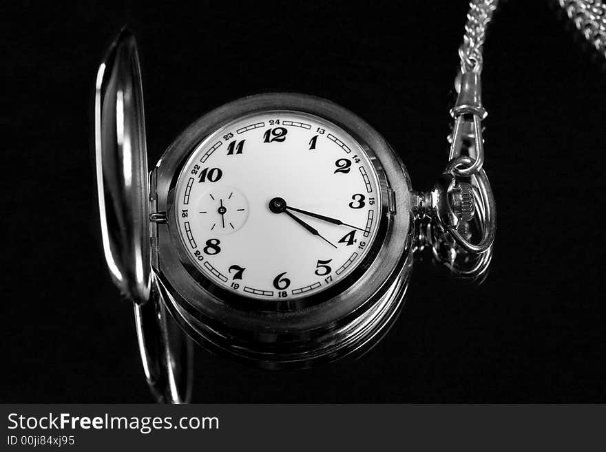 Silver pocket watch on a black background. Silver pocket watch on a black background