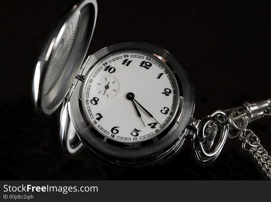 Silver pocket watch on a black background. Silver pocket watch on a black background