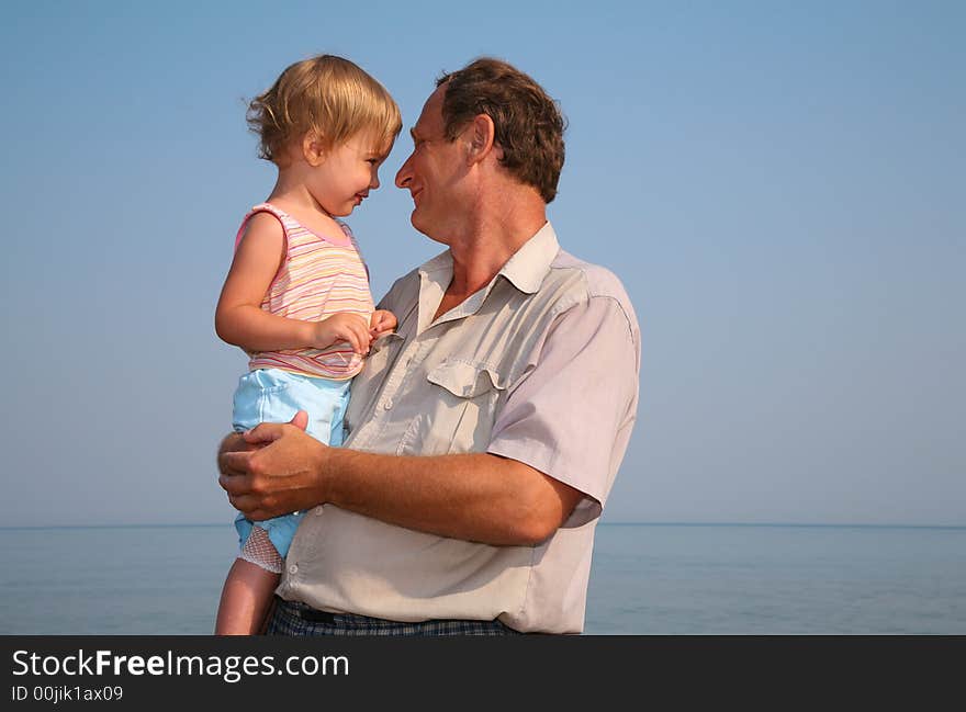 Grandfather holds granddaughter on hands. Grandfather holds granddaughter on hands