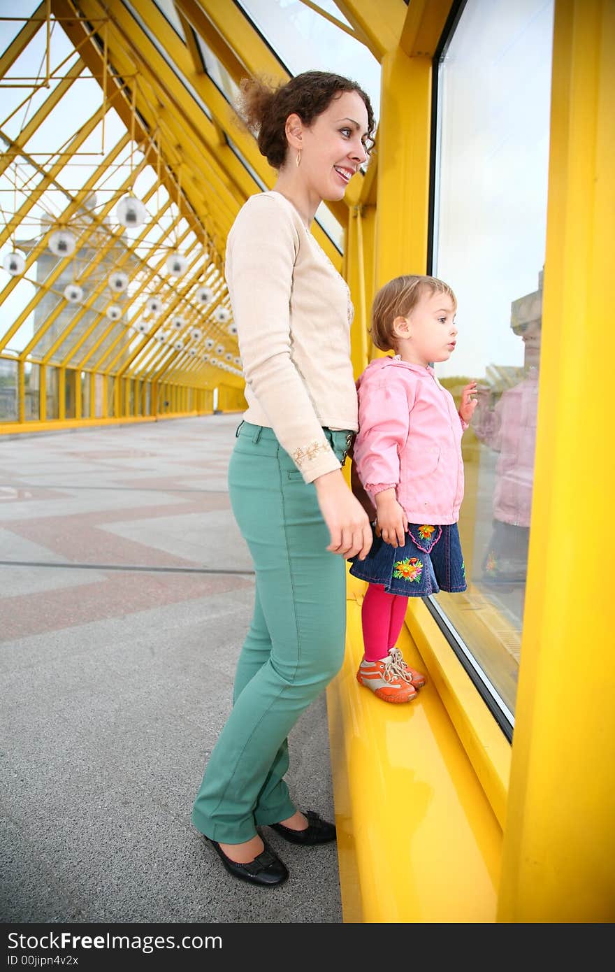 Young woman with baby on pedestrain bridge