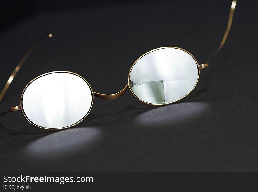 Pair of antique gold-rimmed spectacles, one lens cracked. Pair of antique gold-rimmed spectacles, one lens cracked.