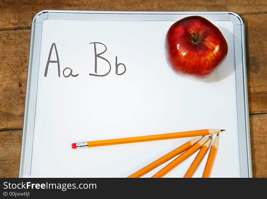 Memo pad with red apple and pencils. Memo pad with red apple and pencils