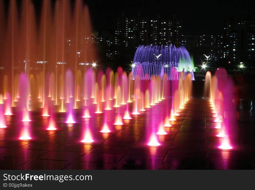 Fountan at night colored water rising with a building background-beautiful sight. Fountan at night colored water rising with a building background-beautiful sight.