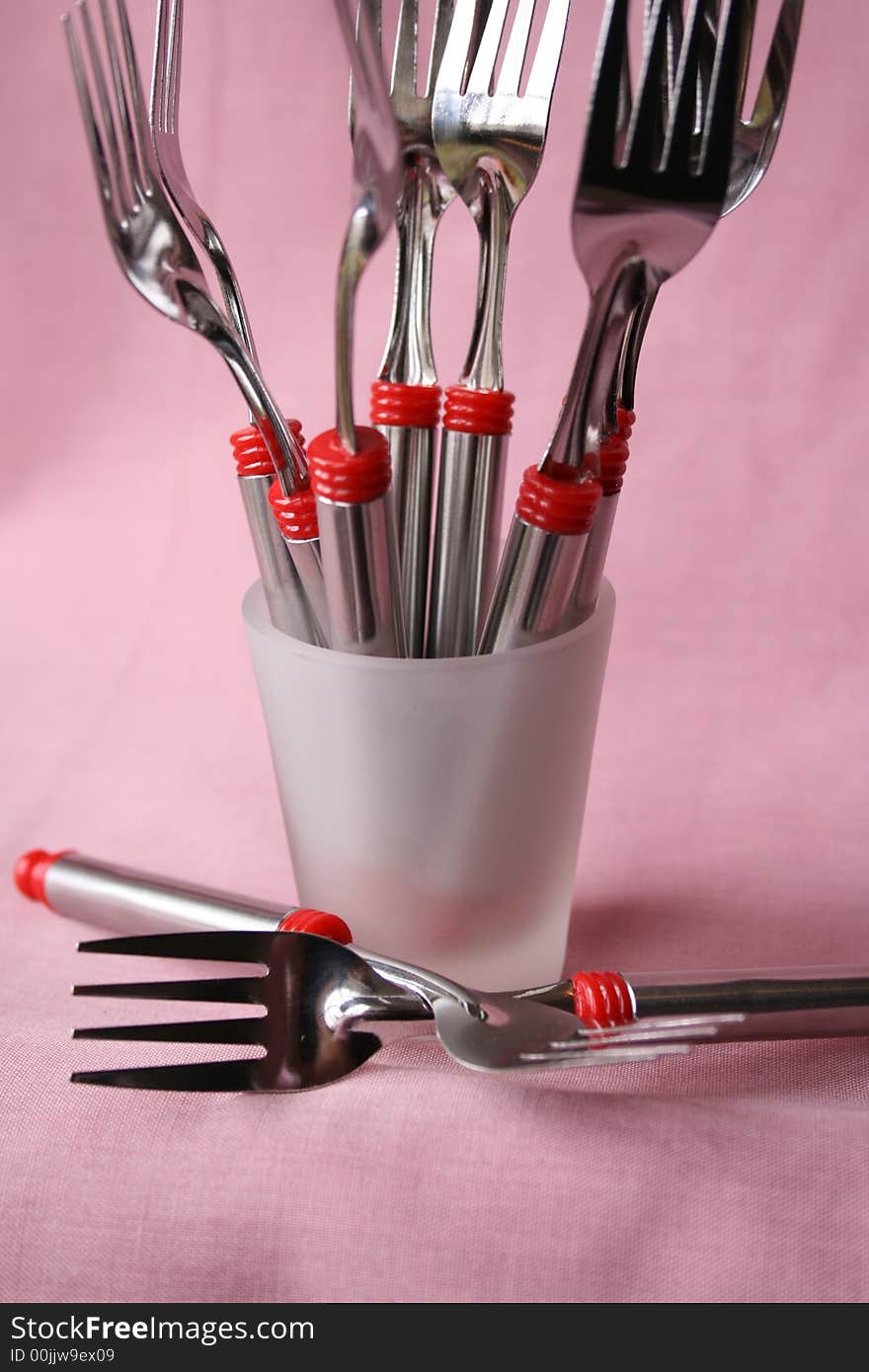 Many forks in a small frosted glass