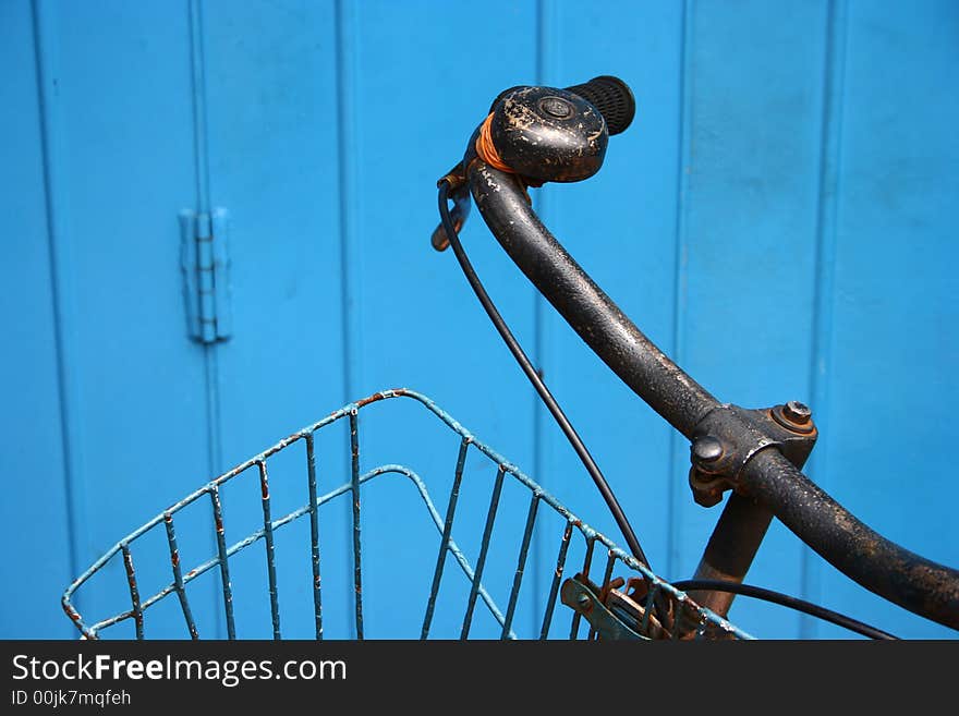 Old bicycle against blue door - detail