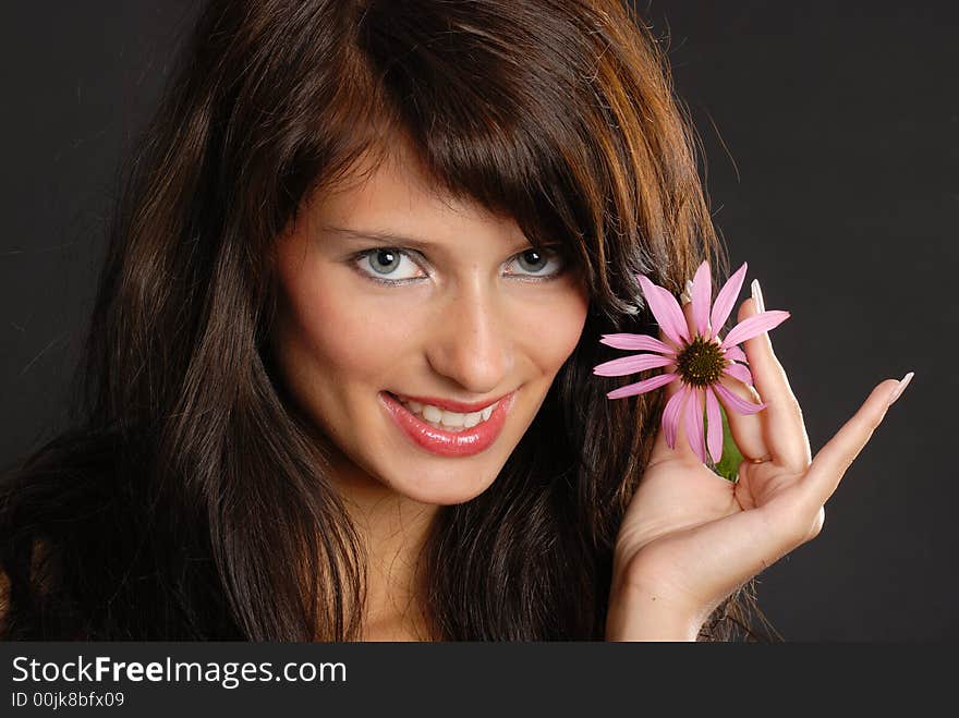 Girl with echinacea-flower on black background