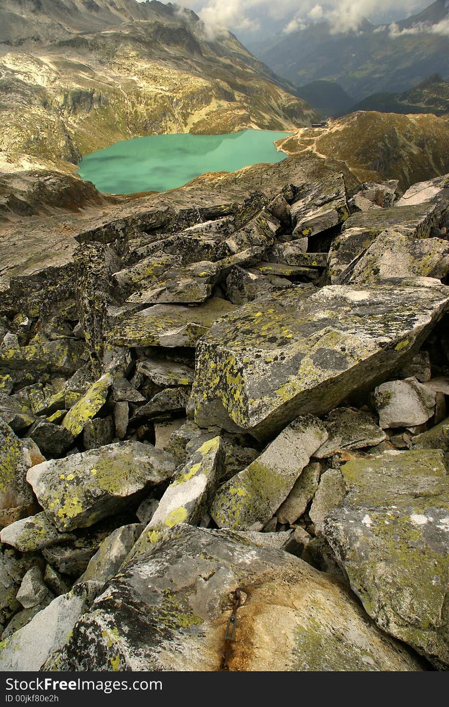 Blue mountain lake with stones in foreground.