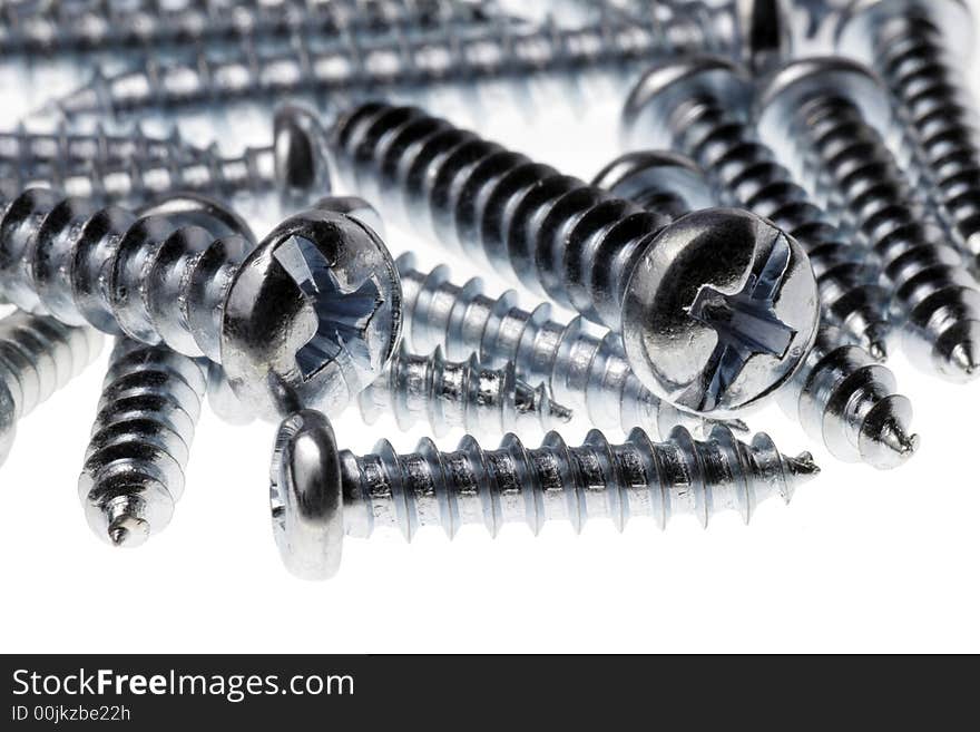 Macro Close-Up Of Spiral Metal Screws On A White Background