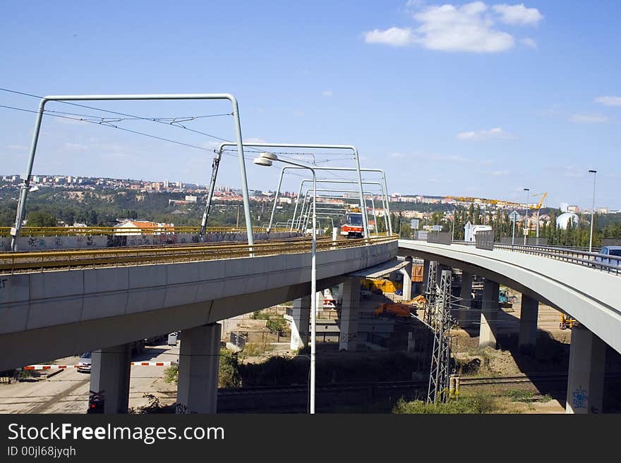 A new tram going down a new bridge in the city. A new tram going down a new bridge in the city