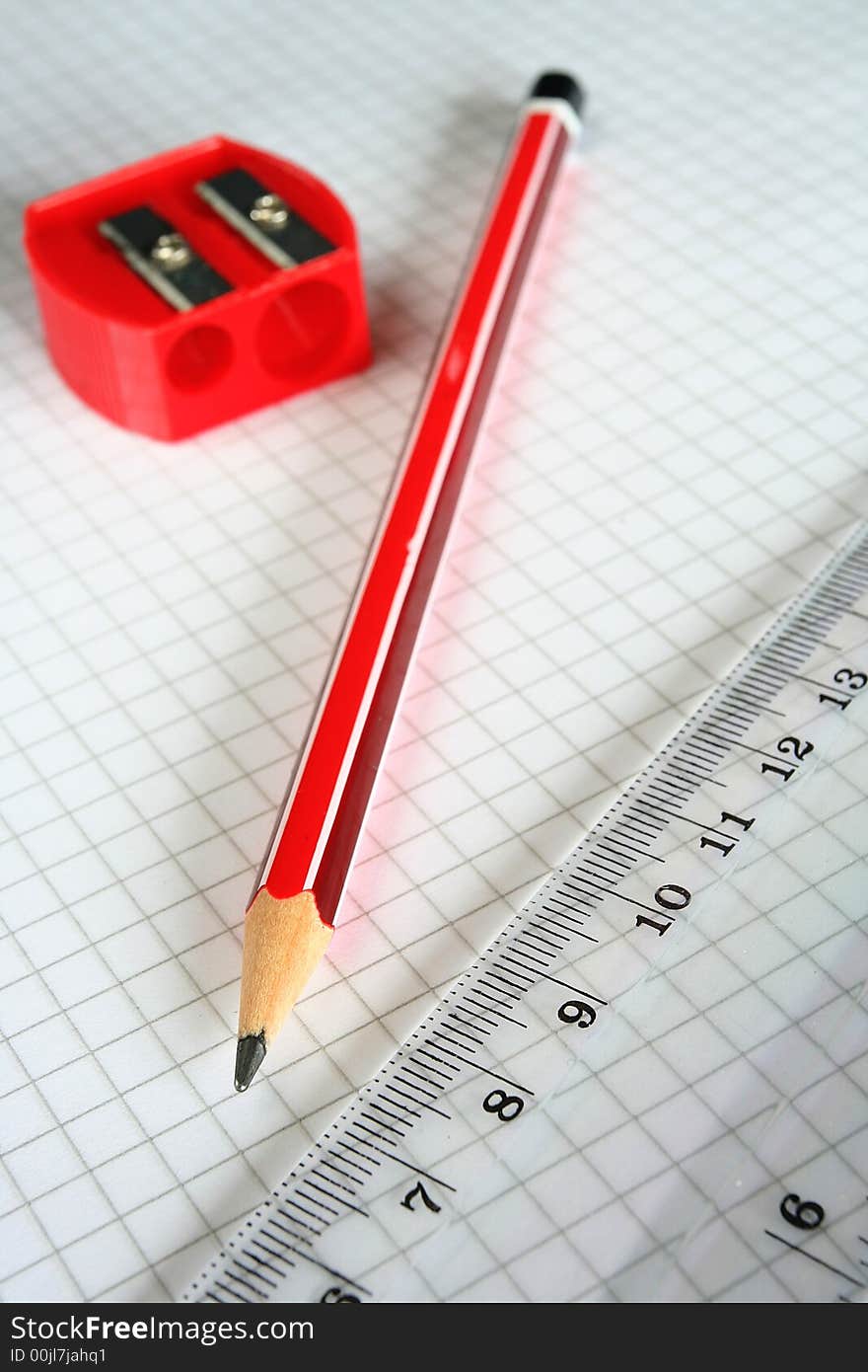 Pencil,sharpener and ruler on grid paper. Pencil,sharpener and ruler on grid paper